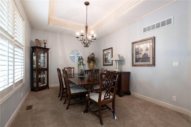 dining area with visible vents, a notable chandelier, light colored carpet, crown molding, and a raised ceiling