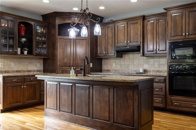 kitchen featuring black appliances, under cabinet range hood, a sink, and recessed lighting