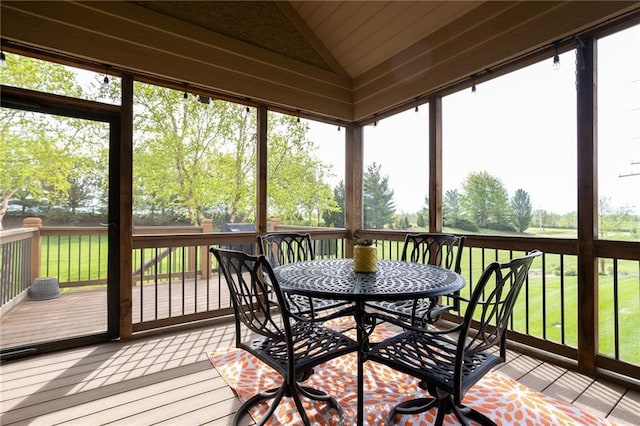 sunroom / solarium featuring outdoor dining area and a wealth of natural light