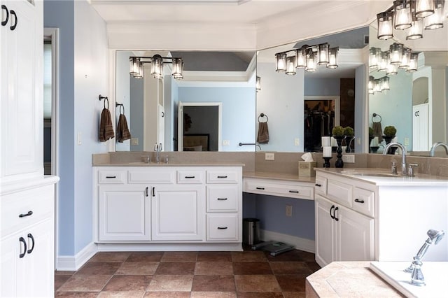 bathroom with two vanities, crown molding, a notable chandelier, and a sink