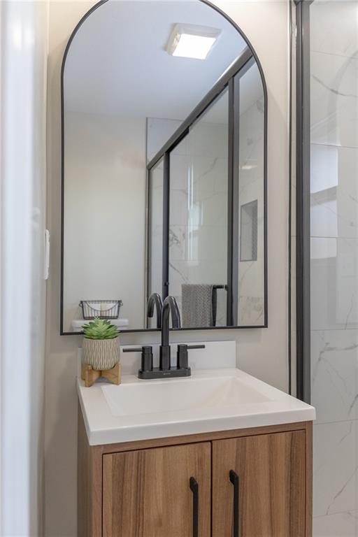 909 Bell Dr, Excelsior Springs, MO 64024 - bathroom featuring vanity and a stall shower