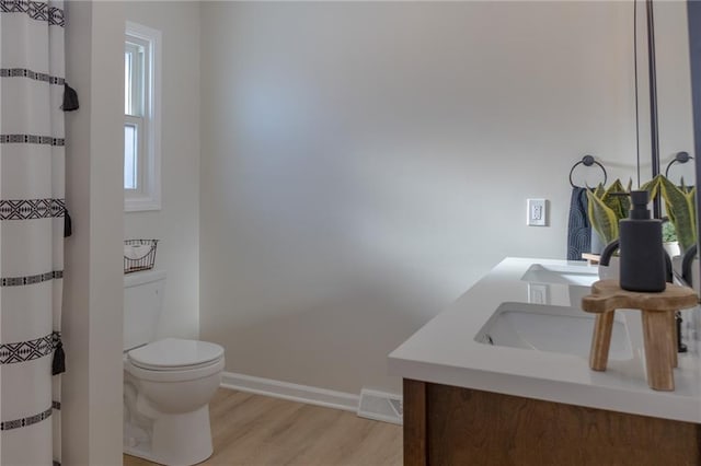 909 Bell Dr, Excelsior Springs, MO 64024 - full bathroom featuring toilet, wood finished floors, vanity, and baseboards