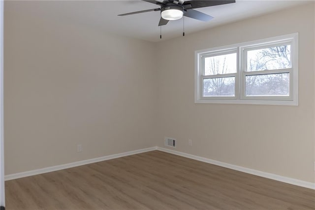 909 Bell Dr, Excelsior Springs, MO 64024 - spare room with wood finished floors, baseboards, and ceiling fan