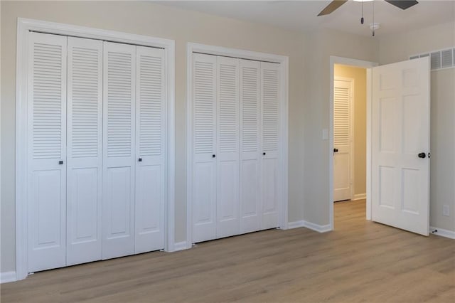 909 Bell Dr, Excelsior Springs, MO 64024 - unfurnished bedroom with two closets, light wood-style floors, and baseboards