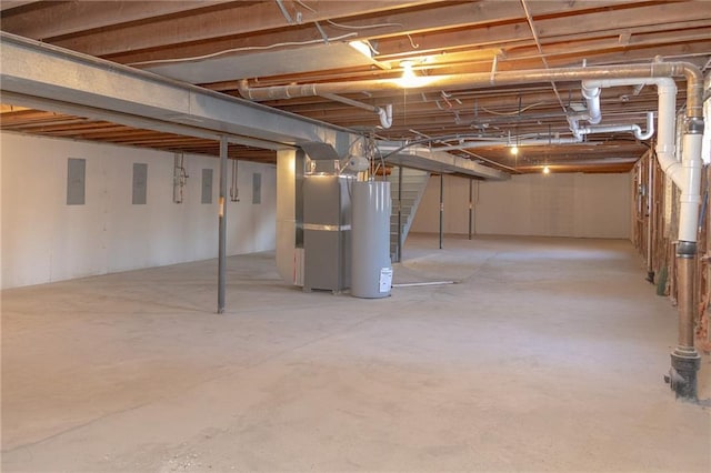 909 Bell Dr, Excelsior Springs, MO 64024 - unfinished below grade area featuring gas water heater, stairway, electric panel, and heating unit