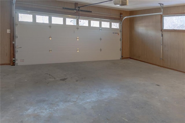 909 Bell Dr, Excelsior Springs, MO 64024 - garage featuring a garage door opener and wooden walls