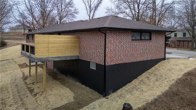 909 Bell Dr, Excelsior Springs, MO 64024 - view of property exterior with a shingled roof and brick siding