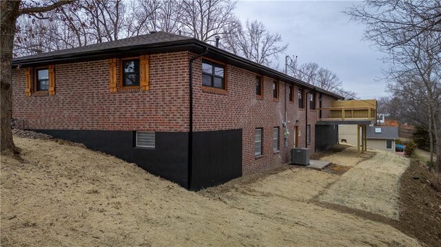 909 Bell Dr, Excelsior Springs, MO 64024 - view of home's exterior with brick siding and central air condition unit