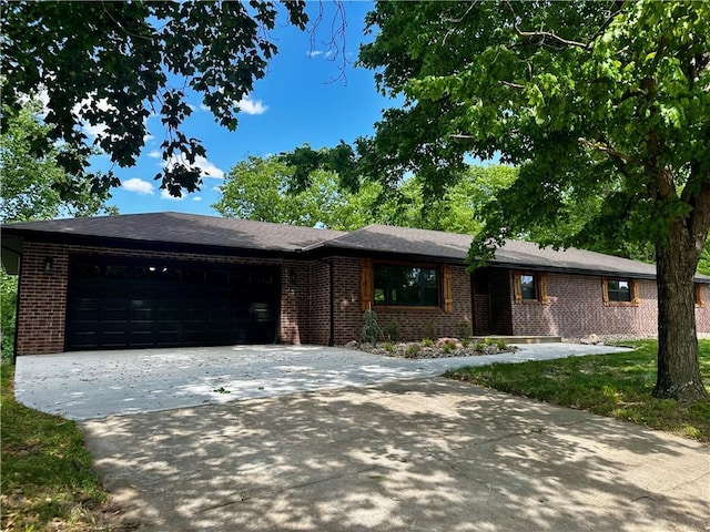 909 Bell Dr, Excelsior Springs, MO 64024 - ranch-style house with brick siding, an attached garage, and concrete driveway