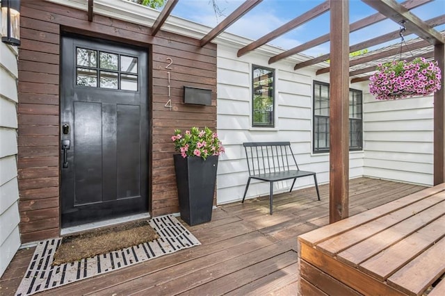 property entrance featuring a pergola and a wooden deck