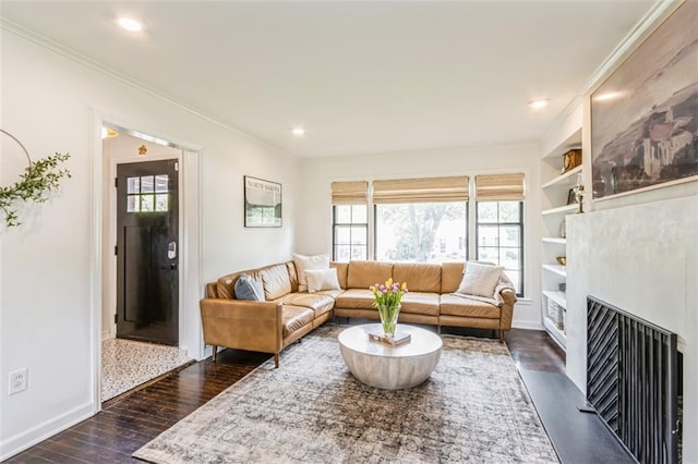 living area with baseboards, ornamental molding, dark wood finished floors, and a wealth of natural light