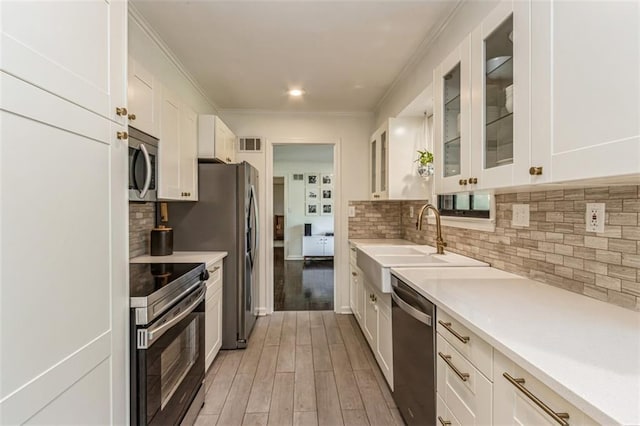 kitchen with visible vents, a sink, white cabinets, and stainless steel appliances