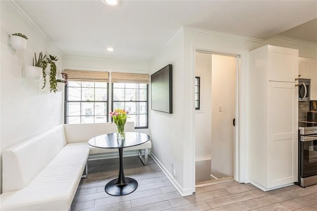 interior space featuring recessed lighting, baseboards, ornamental molding, and light wood-style flooring