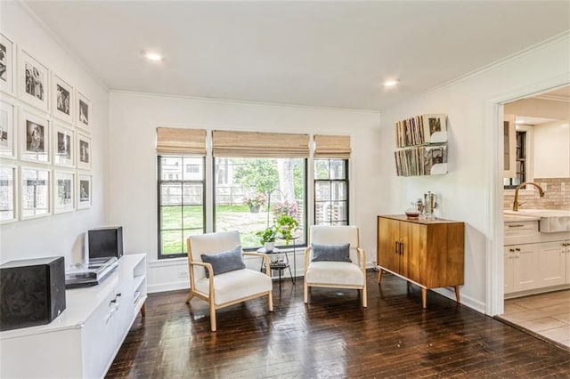 sitting room with ornamental molding and hardwood / wood-style flooring