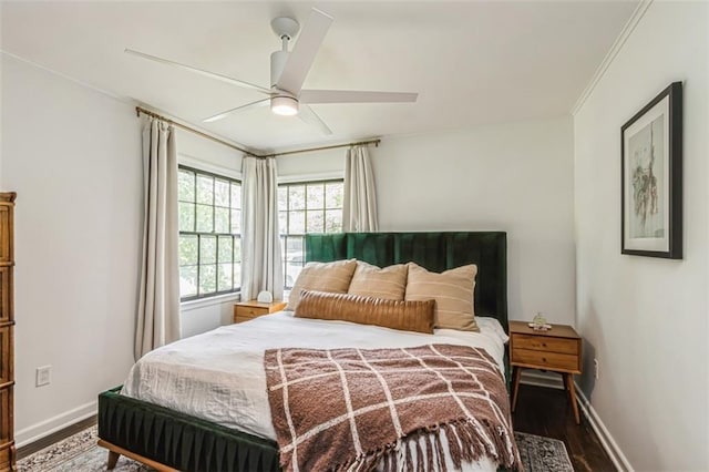 bedroom with crown molding, a ceiling fan, baseboards, and wood finished floors