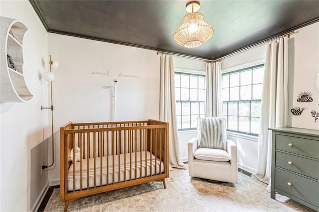bedroom featuring baseboards, carpet flooring, and a nursery area