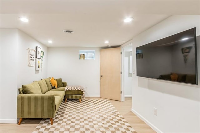 living room featuring baseboards, light wood finished floors, recessed lighting, and visible vents