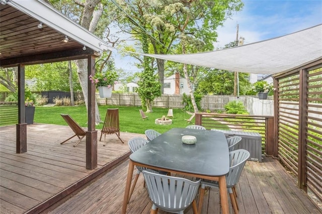 wooden terrace featuring a lawn, a fenced backyard, and outdoor dining area