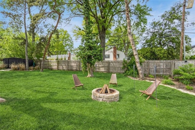 view of yard with a fenced backyard and a fire pit