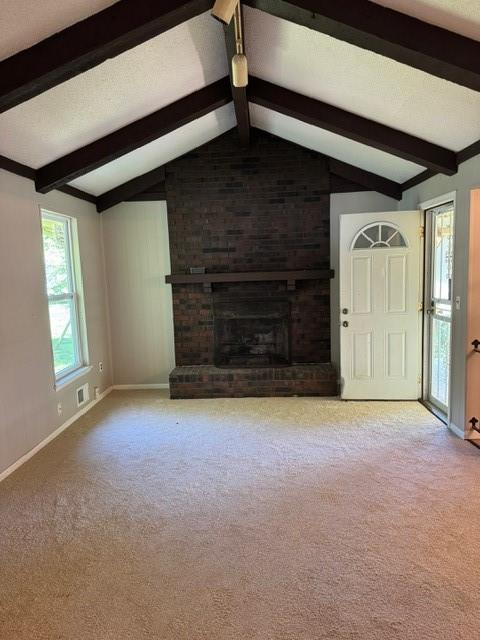 7722 E 90th Ter, Kansas City, MO 64138 - unfurnished living room with baseboards, carpet flooring, and a brick fireplace