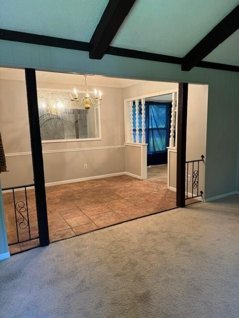7722 E 90th Ter, Kansas City, MO 64138 - carpeted spare room featuring beamed ceiling, a chandelier, baseboards, and tile patterned flooring