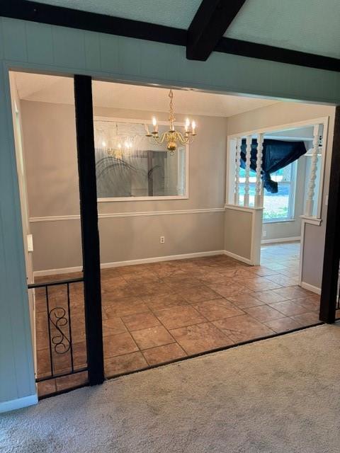 7722 E 90th Ter, Kansas City, MO 64138 - tiled spare room with a chandelier, beam ceiling, baseboards, and carpet