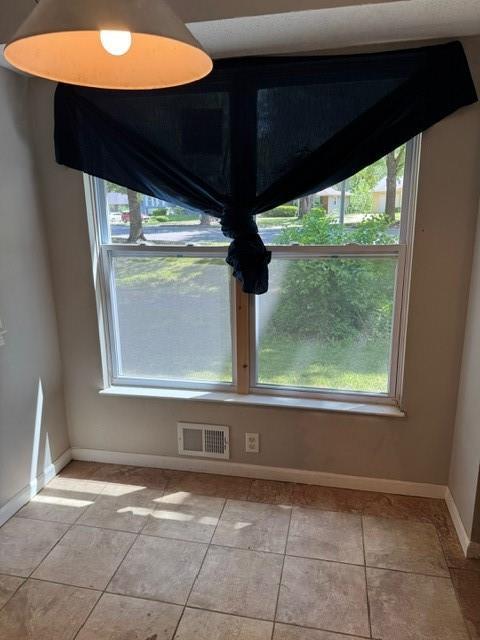 7722 E 90th Ter, Kansas City, MO 64138 - unfurnished dining area with light tile patterned flooring and baseboards