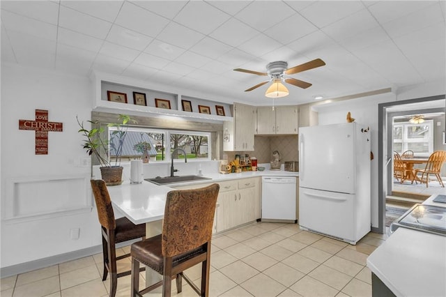 kitchen featuring a sink, light countertops, a ceiling fan, and white appliances