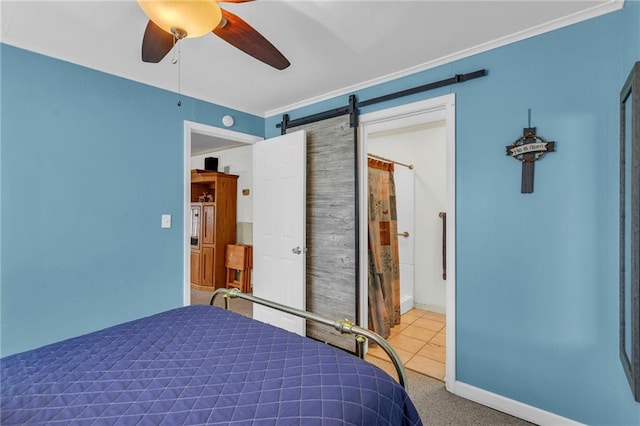 bedroom featuring a ceiling fan, a barn door, carpet floors, baseboards, and ornamental molding