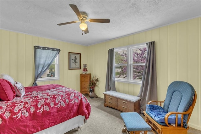 carpeted bedroom with multiple windows, a ceiling fan, and a textured ceiling