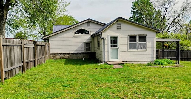 back of property with a fenced backyard and a yard