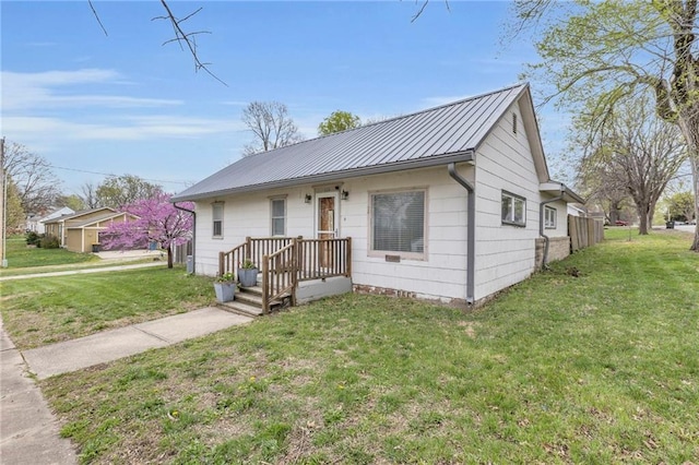 bungalow-style house with metal roof and a front yard