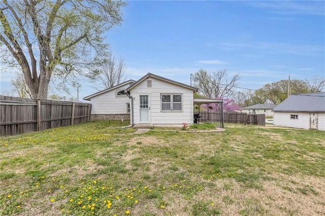 rear view of house with a yard and fence