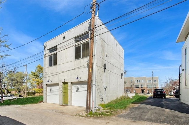1610 Summit St, Kansas City, MO 64108 - view of side of property with a garage and driveway