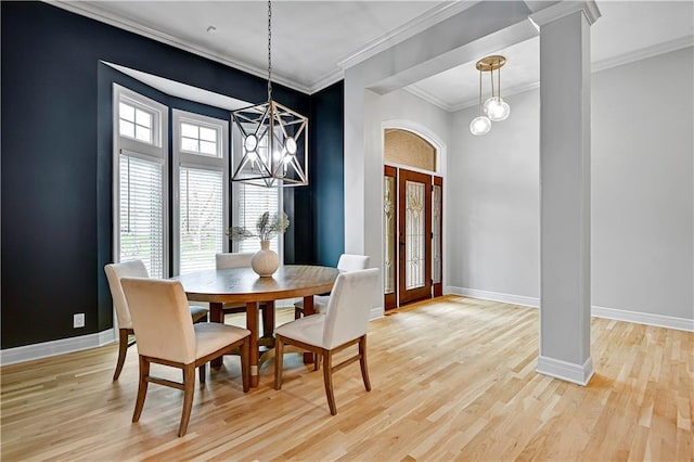 dining space with crown molding, baseboards, an inviting chandelier, and plenty of natural light