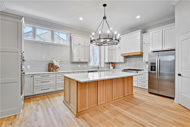 kitchen featuring plenty of natural light, appliances with stainless steel finishes, and ornamental molding