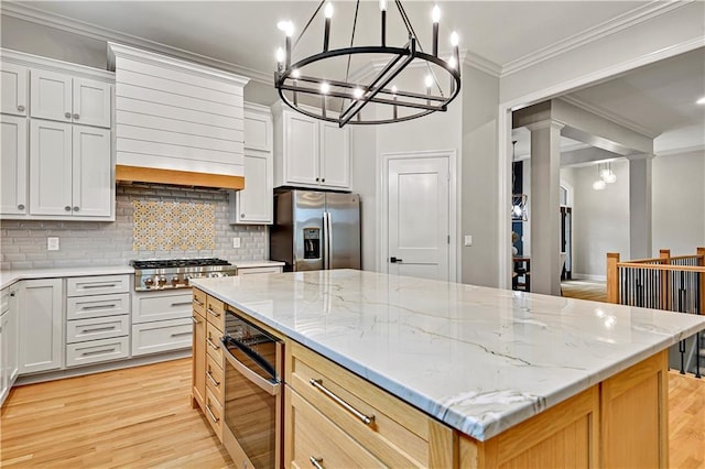 kitchen with light wood-style floors, a chandelier, and stainless steel appliances