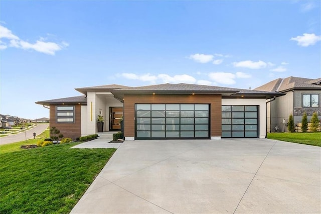 prairie-style house with concrete driveway, a front lawn, and a garage