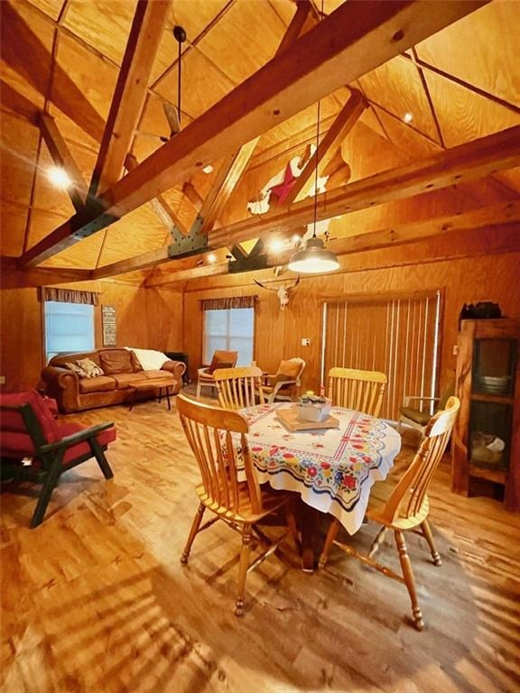 518 SW Lakeside Dr, La Cygne, KS 66040 - dining space with wood walls, beamed ceiling, wood finished floors, and high vaulted ceiling