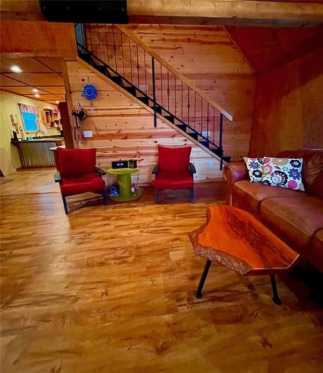 518 SW Lakeside Dr, La Cygne, KS 66040 - living room featuring wood walls, wood finished floors, and stairs