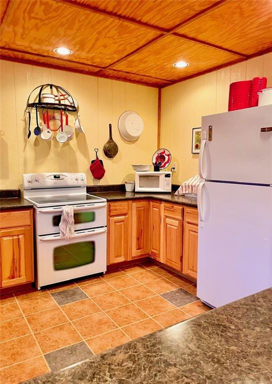 518 SW Lakeside Dr, La Cygne, KS 66040 - kitchen featuring white appliances, wood ceiling, dark countertops, and recessed lighting