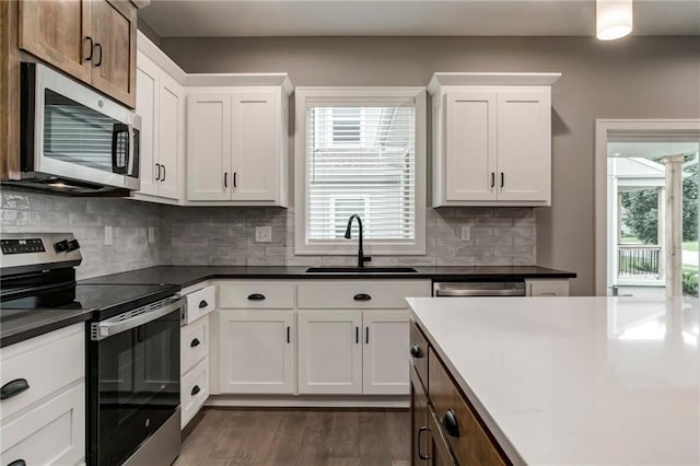 16827 W 164th Ter, Olathe, KS 66062 - kitchen featuring appliances with stainless steel finishes, dark wood-type flooring, white cabinets, and dark countertops