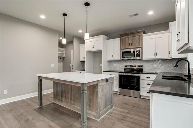 16827 W 164th Ter, Olathe, KS 66062 - kitchen featuring appliances with stainless steel finishes, tasteful backsplash, light wood-style floors, and recessed lighting