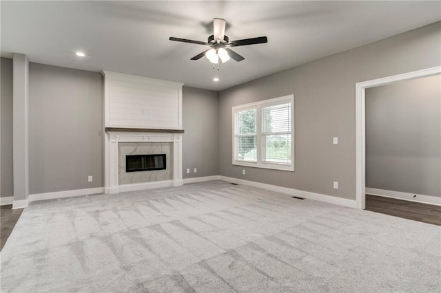 16827 W 164th Ter, Olathe, KS 66062 - unfurnished living room with carpet flooring, a ceiling fan, a premium fireplace, and recessed lighting