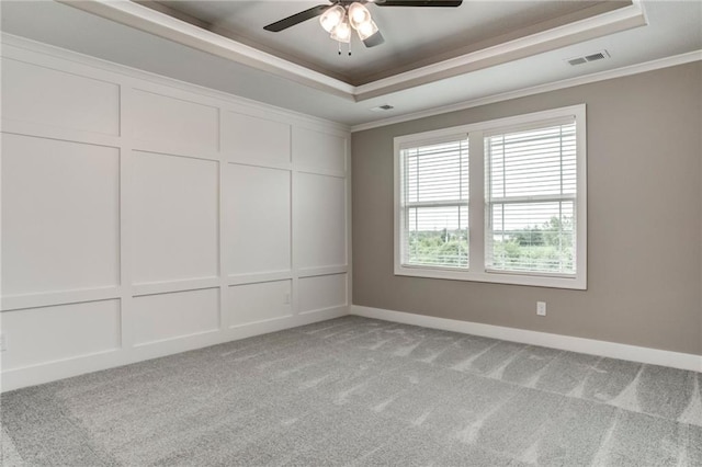 16827 W 164th Ter, Olathe, KS 66062 - spare room featuring a tray ceiling, light colored carpet, ceiling fan, ornamental molding, and a decorative wall
