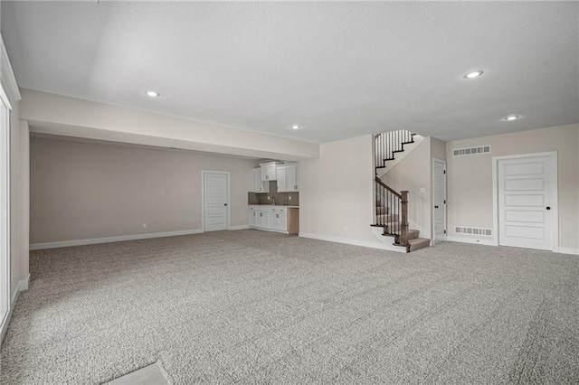 19389 W 114th Ter, Olathe, KS 66061 - unfurnished living room featuring baseboards, stairs, recessed lighting, and carpet flooring