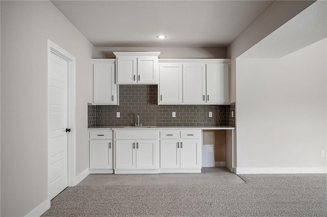 19389 W 114th Ter, Olathe, KS 66061 - kitchen featuring light carpet, light countertops, white cabinetry, decorative backsplash, and a sink