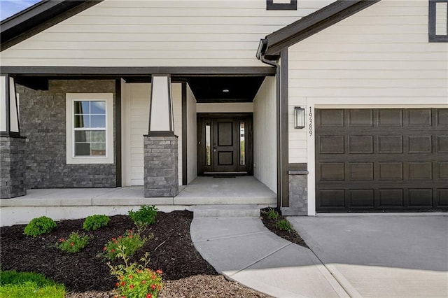 19389 W 114th Ter, Olathe, KS 66061 - view of exterior entry with an attached garage and stone siding
