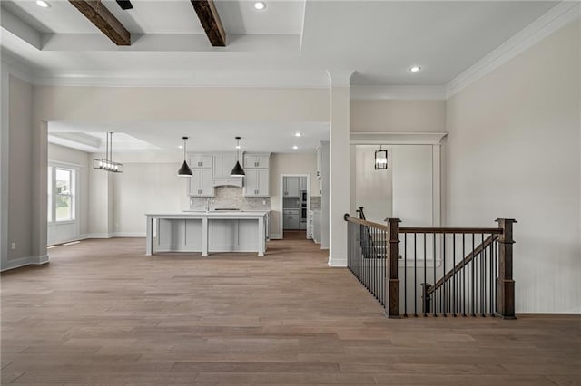 19389 W 114th Ter, Olathe, KS 66061 - kitchen featuring light wood-style flooring, a kitchen island with sink, beam ceiling, recessed lighting, and light countertops