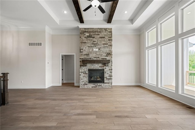 19389 W 114th Ter, Olathe, KS 66061 - unfurnished living room with ceiling fan, healthy amount of natural light, beamed ceiling, wood finished floors, and a fireplace